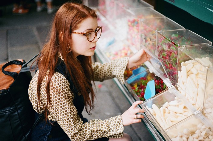 Redhead woman with glasses shopping for candy
