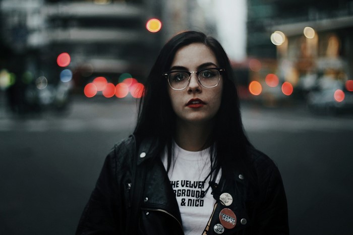 Woman with glasses and leather jacket in city