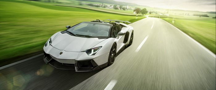 White Lamborghini Aventador driving on a country road