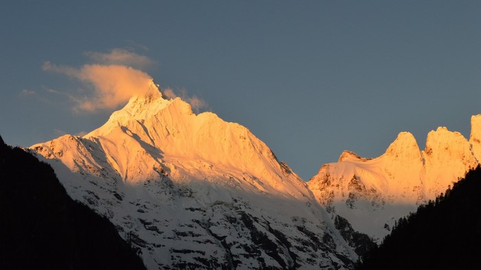 Snow-capped mountains illuminated by sunset light