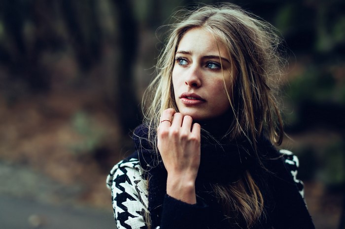 Woman with blonde hair and blue eyes wearing a patterned coat