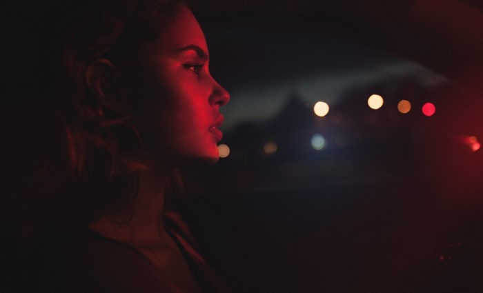 Woman illuminated by red light at night