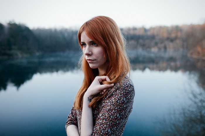 Woman with red hair by a lake