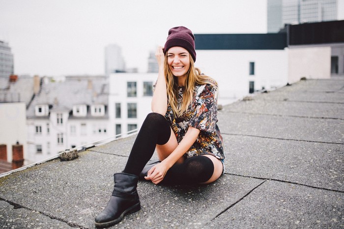 Woman in beanie and knee-high socks on rooftops