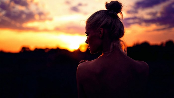 Woman silhouetted against a sunset