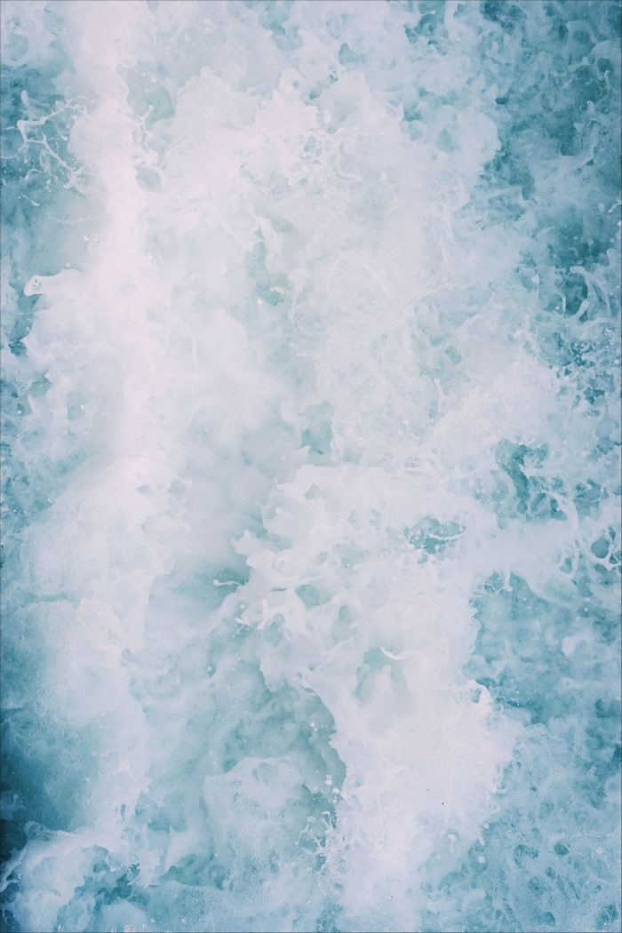 Abstract close-up of turbulent blue water with white foam