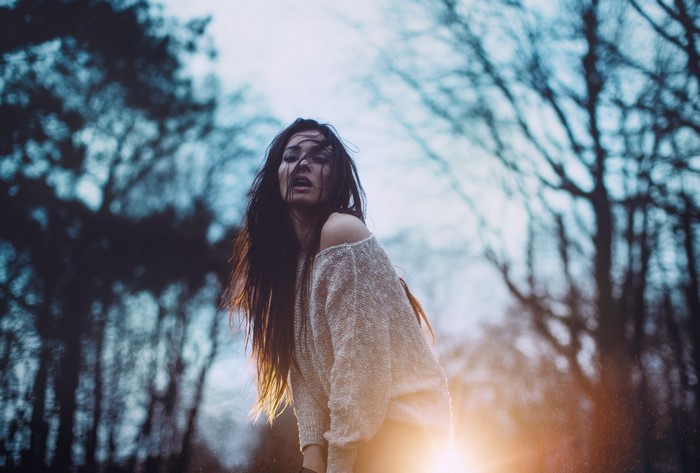 Woman with hair in face in a forest
