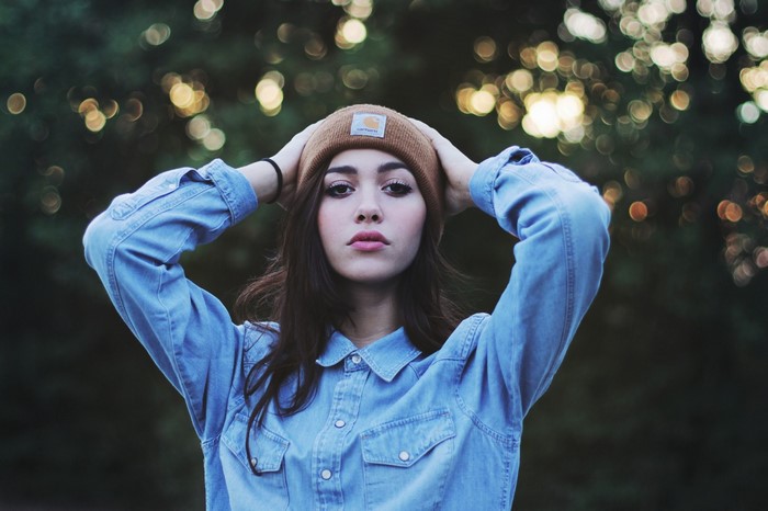 Woman wearing a beanie and denim shirt