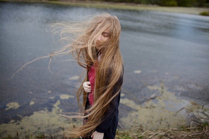 Woman with long hair by a lake
