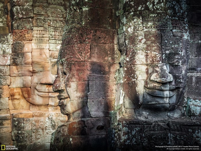 Ancient stone faces carved into a temple wall