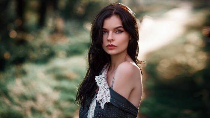 Woman with long dark hair and blue eyes in a dress
