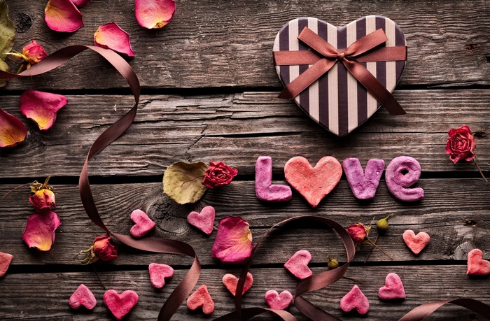Love decorations with heart-shaped gift box and rose petals
