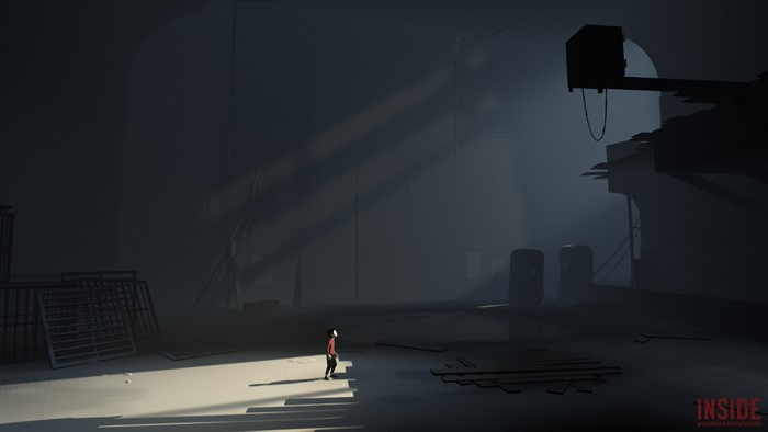 Boy in red shirt in dark industrial area from Inside