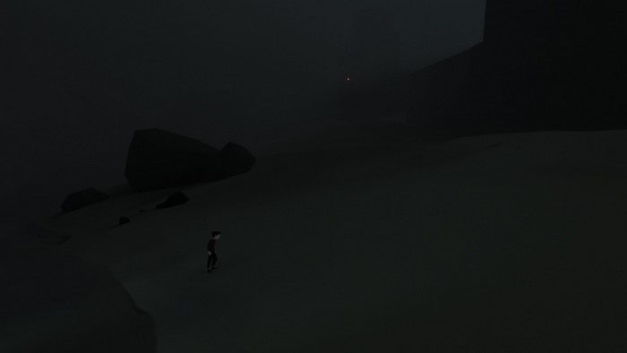 Boy in dark foggy landscape with rocks