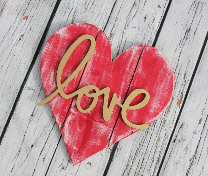 Red heart with the word "love" on a wooden background