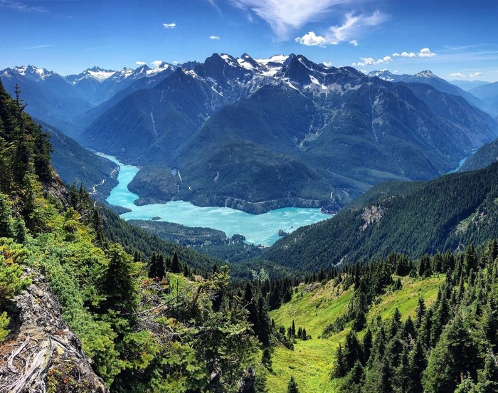 Turquoise lake surrounded by mountains and forests