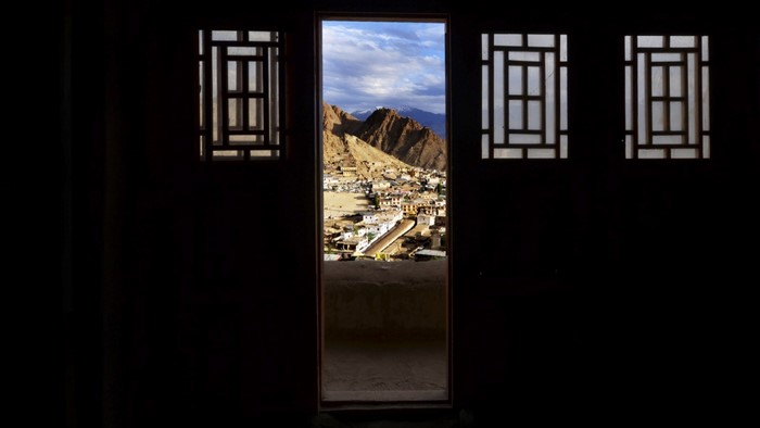 View of a town and mountains through a doorway