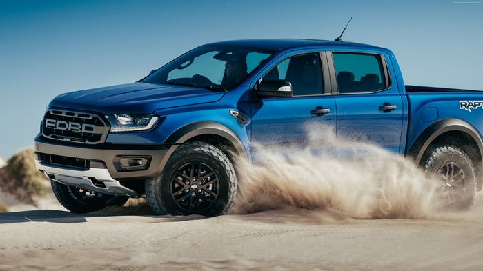 Blue Ford Ranger Raptor driving on sand