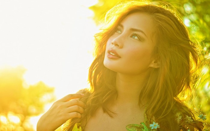 Woman with long brown hair in sunlight