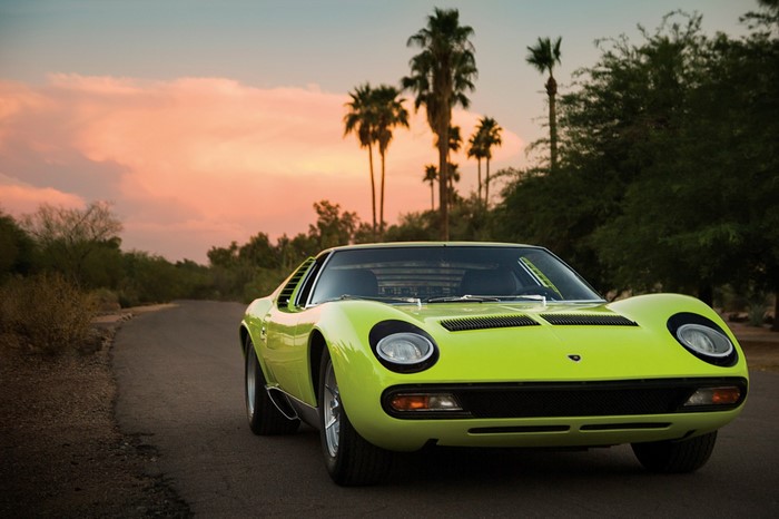 Lime green Lamborghini Miura on a road at sunset