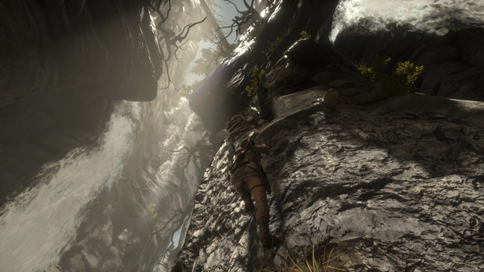 Lara Croft climbing a rocky cliff with a waterfall