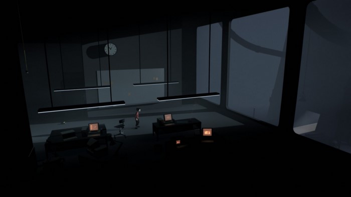 Boy in dark office with computers and large windows