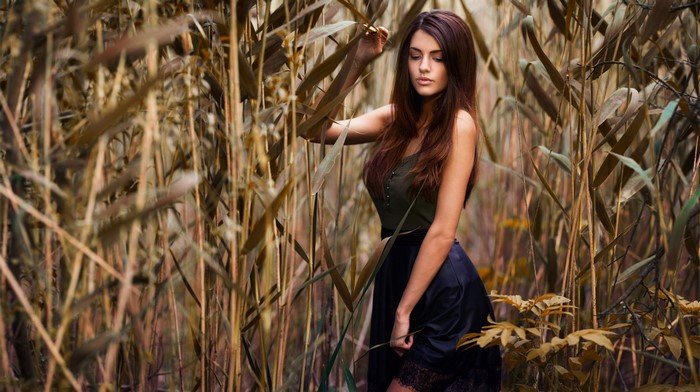 Woman in a skirt posing in tall grass