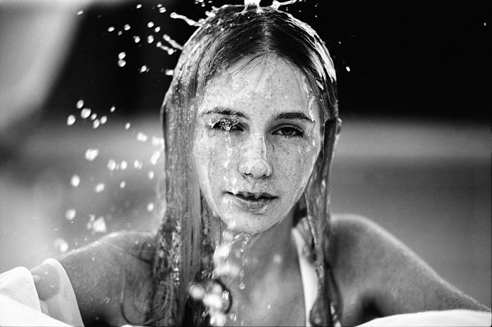Monochrome portrait of a young woman with freckles and wet hair