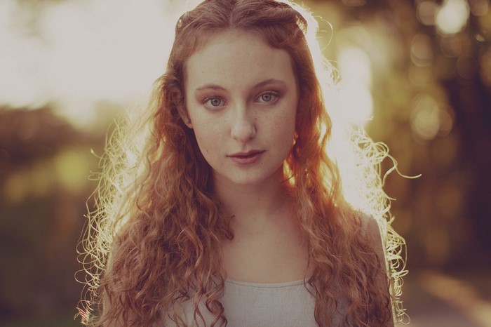 Young woman with red curly hair and freckles