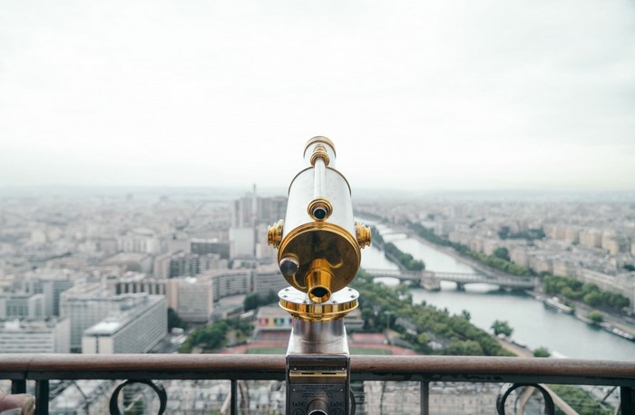Telescope overlooking a cityscape with a river
