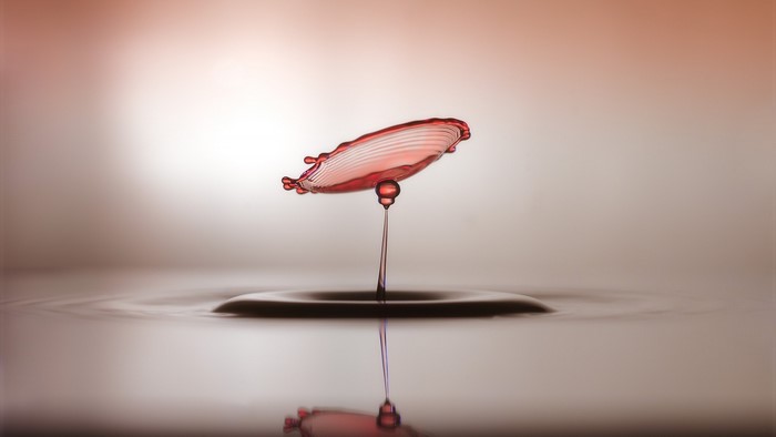 Red water drop splash with reflection