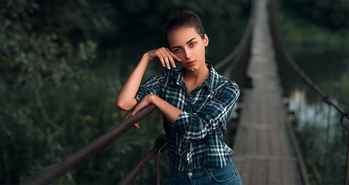 Woman in plaid shirt on a suspension bridge