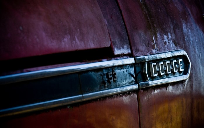Close up of a rusty red Dodge truck emblem