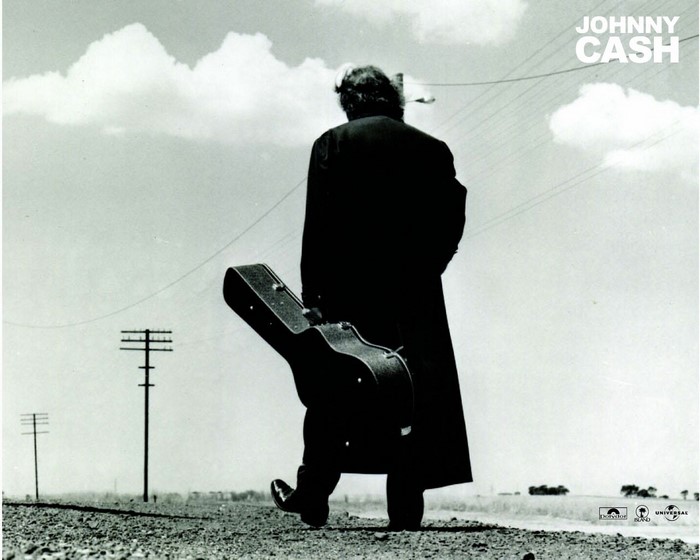 Johnny Cash walking with guitar case