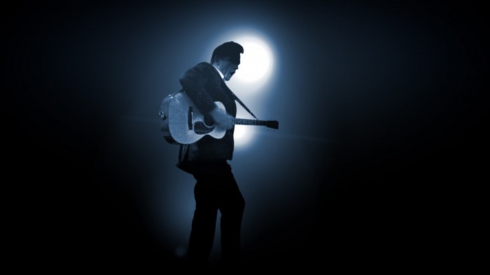 Johnny Cash playing guitar in silhouette