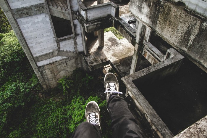 Person sitting on edge of abandoned building