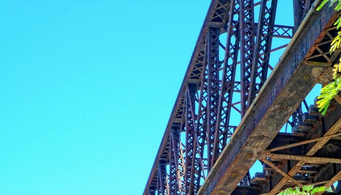 Rusty steel bridge against a clear blue sky