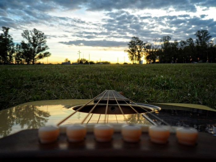 Acoustic guitar on grass at sunset