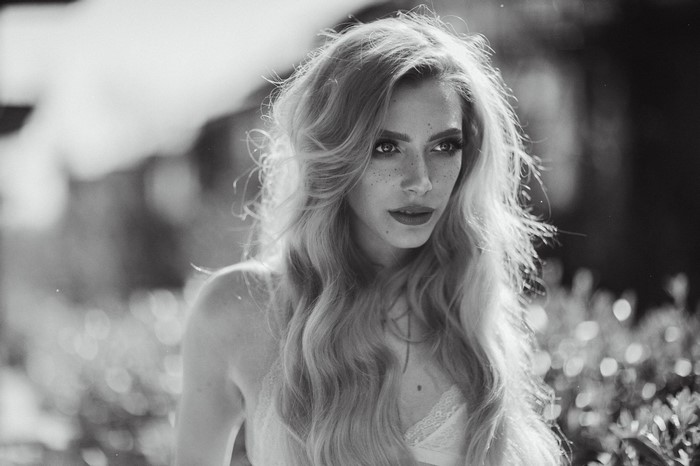 Monochrome portrait of a woman with long wavy hair and freckles