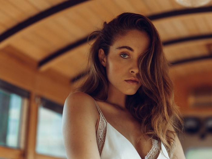 Woman with long brown hair in a white dress