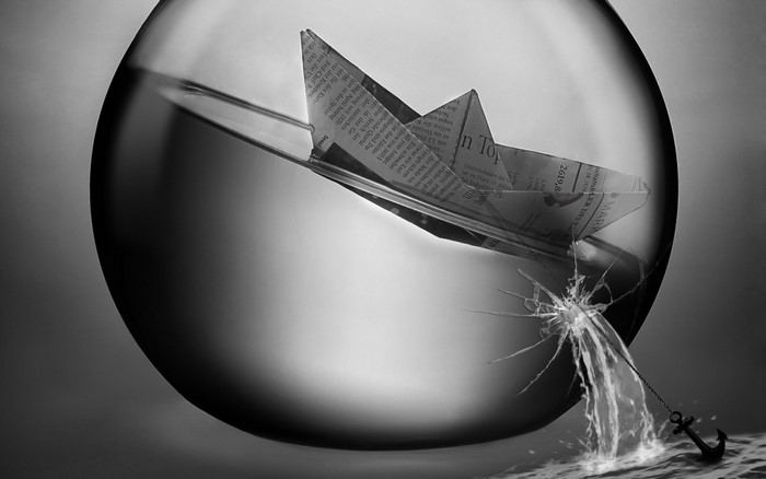 Paper boat in broken glass sphere with anchor
