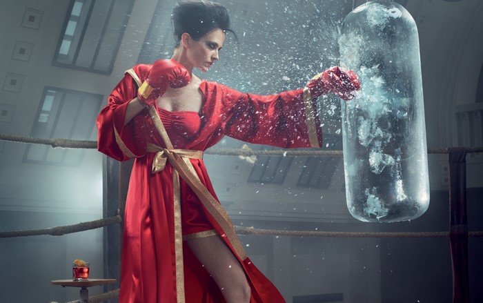 Eva Green in a red robe boxing a punching bag