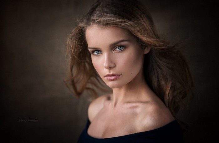 Woman with flowing brown hair and blue eyes