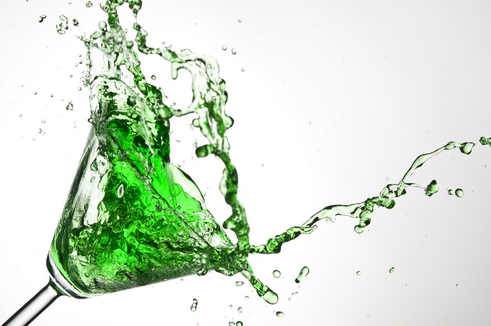 Green cocktail splash in martini glass
