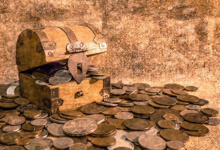 Wooden treasure chest overflowing with coins