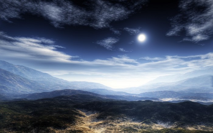 Misty mountain landscape with sun and clouds