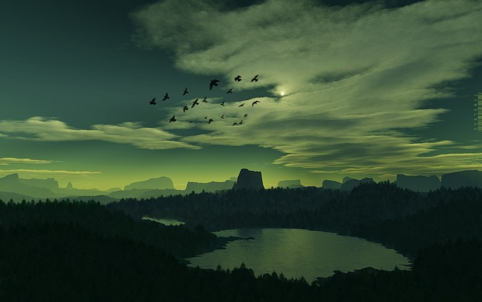 Birds flying over a lake and mountains at dusk