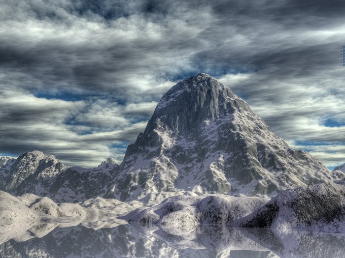 Snowy mountain range reflected in water under cloudy sky