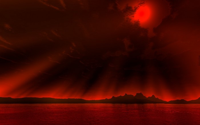 Red sky over water with mountains and sun