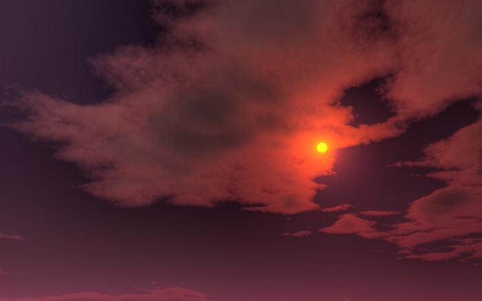 Sun setting behind clouds in a red sky